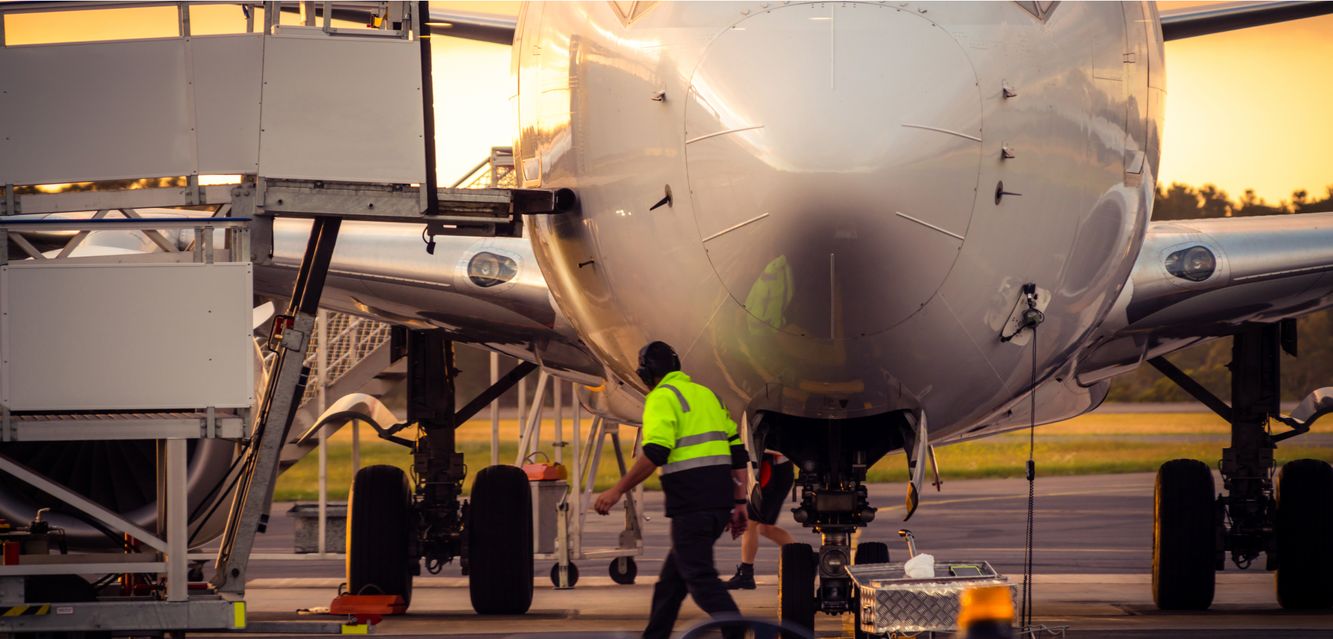 Crew checking the airplane parked at the airport runway.